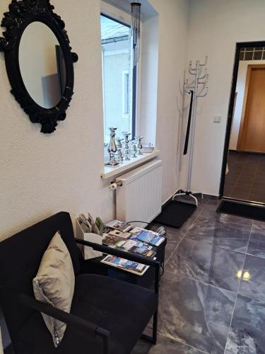 a living room with a black chair and a mirror at Apartment MICHAELA in Spital am Pyhrn
