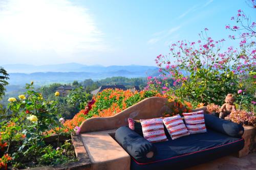 a couch sitting in a field of flowers at Phu Chaisai Chiang Rai Mountain Resort in Mae Salong Nai