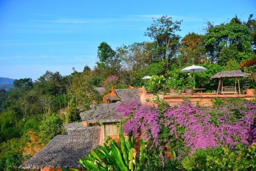 a house with purple flowers on a hill at Phu Chaisai Chiang Rai Mountain Resort in Mae Salong Nai