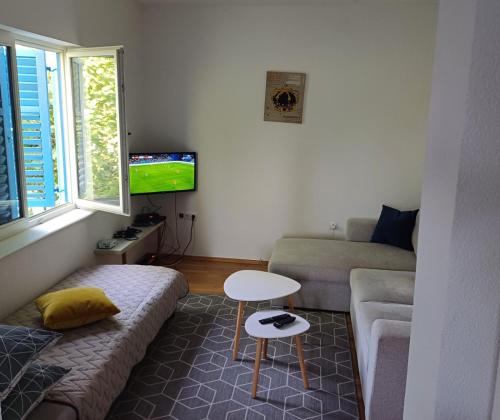 a living room with a couch and a tv at Villa Cataleya Počitelj in Počitelj