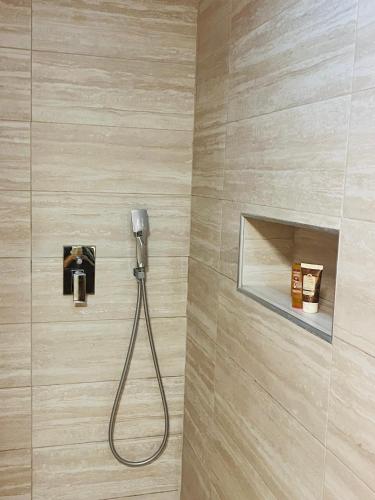 a shower with a hose attached to a wall at ViMaJU in Koper