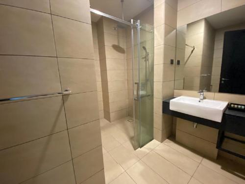 Un baño con ducha de cristal y lavabo. en Kuala Lumpur Apartment at Opus Residence Near China Town and 118 Tower, en Kuala Lumpur