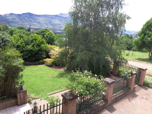 a garden with a fence and a field of grass at Clarens Mount Rose self-catering holiday house in Clarens
