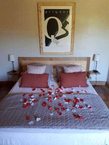 a bed with a bunch of red flowers on it at Aux berges du pont du gard in Vers Pont du Gard