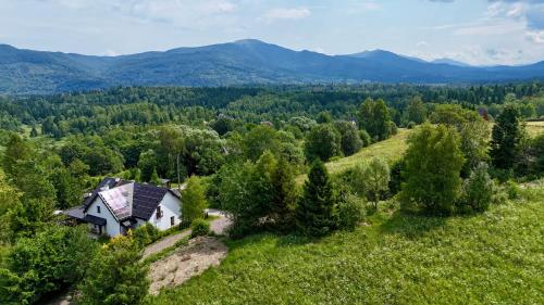 - une vue aérienne sur une maison située sur une colline avec des montagnes dans l'établissement Błyszczowe Berce, à Strzebowiska