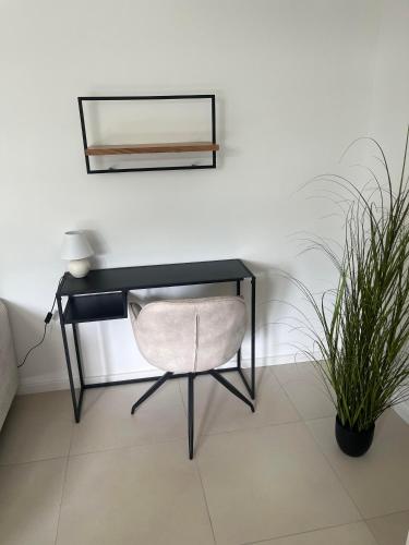 a desk with a chair and a mirror and a plant at Gemini Lux - Sun Balaton in Balatonkenese