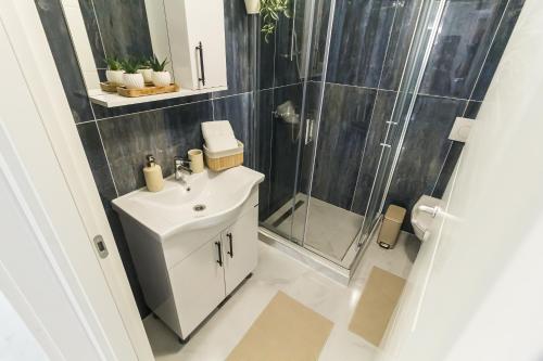 a bathroom with a sink and a shower at Isa Residence - Otopeni Airport & Therme I Libertatii Gardens - free pool facilities in Otopeni