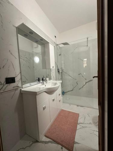 a white bathroom with a sink and a shower at Villa Lollo in Camporosso