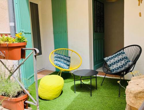 a patio with two chairs and a table and a yellow chair at Cosy studio aix en Provence à 1 minutes du cours Mirabeau in Aix-en-Provence