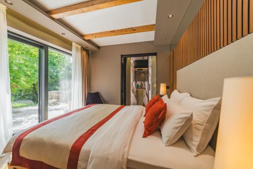 a bedroom with a large bed with pillows and a window at Diamonte Villas Collection in Tivat