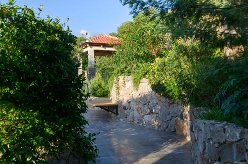 a stone wall with a bench in front of a house at Diamonte Villas Collection in Tivat