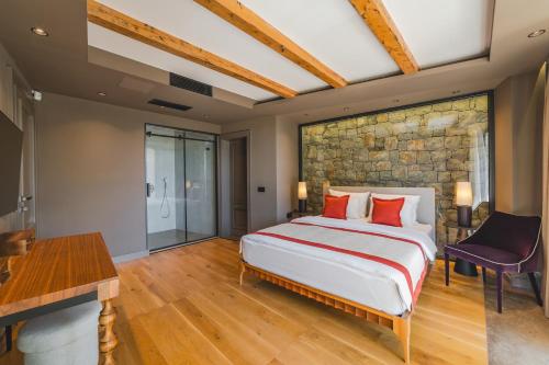 a bedroom with a large bed and a stone wall at Diamonte Villas Collection in Tivat