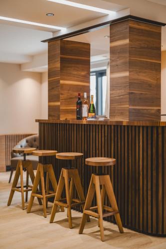 a bar with wooden stools and bottles of wine at Diamonte Villas Collection in Tivat