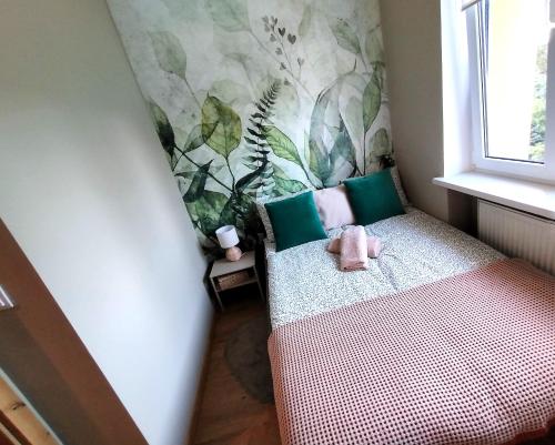 a small room with a bed with a flowery wallpaper at Oaza w Centrum - Apartament Tarnowskie Góry in Tarnowskie Góry