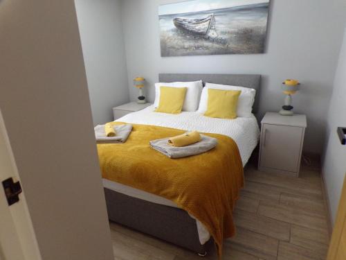 a bedroom with a bed with two towels on it at 4 The Dome, Barton on sea - Where Comfort Meets the Coast in Barton on Sea