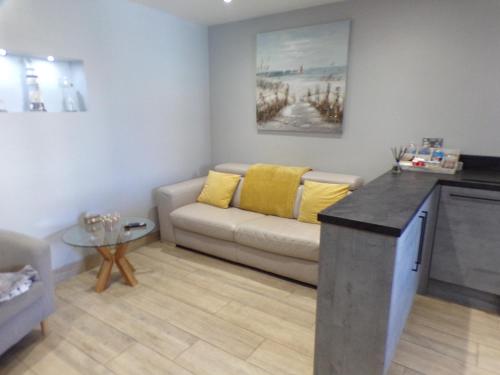 a living room with a couch and a table at 4 The Dome, Barton on sea - Where Comfort Meets the Coast in Barton on Sea