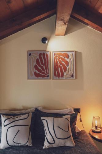 a bedroom with two pictures on the wall above a bed at Il fienile di Rosy in Ardenno
