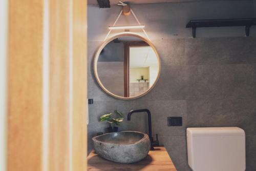 a bathroom with a stone sink and a mirror at Il fienile di Rosy in Ardenno