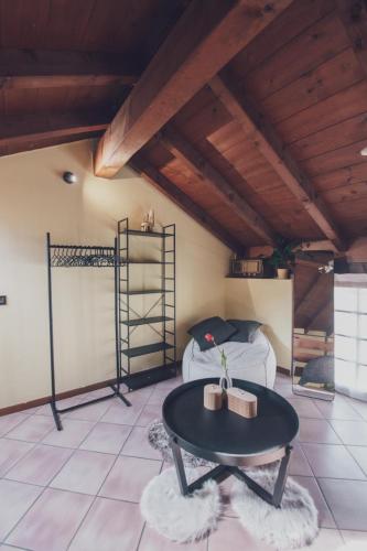 a room with a table and a bed in a attic at Il fienile di Rosy in Ardenno