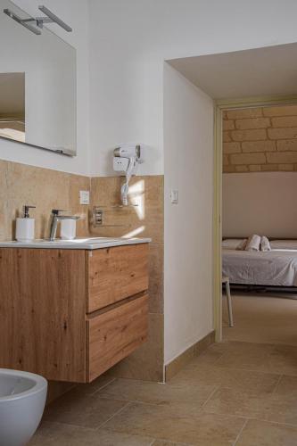 a bathroom with a sink and a bed in a room at Agriturismo Masseria Sbotta in SantʼAndrea
