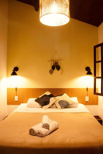 a bedroom with a large bed with towels on it at Calmaria Suítes Búzios in Búzios