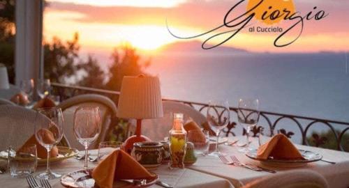 a table with a white table cloth with a view of the ocean at Villa DAlessandro in Anacapri