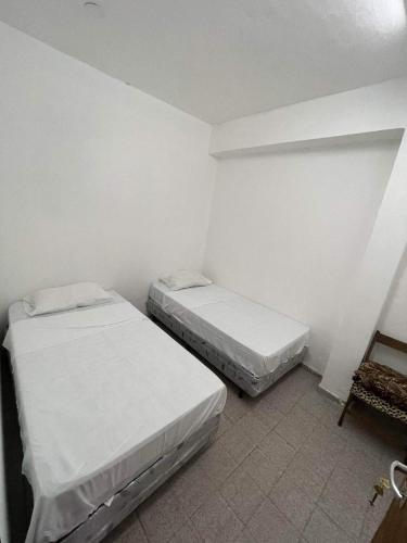 two beds in a small room with white walls at Amelia in Resistencia