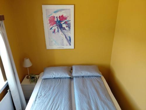 a bedroom with a bed and a picture on the wall at Árbakki-Guesthouse near Egilsstaðir in Stóri-Bakki