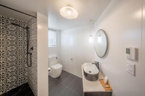 a bathroom with a shower and a toilet and a sink at Prince's Gate Hotel in Rotorua