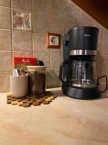 a coffee maker on a counter next to a pile of cookies at Cosy Nest Apartment in the Heart of Samos in Samos