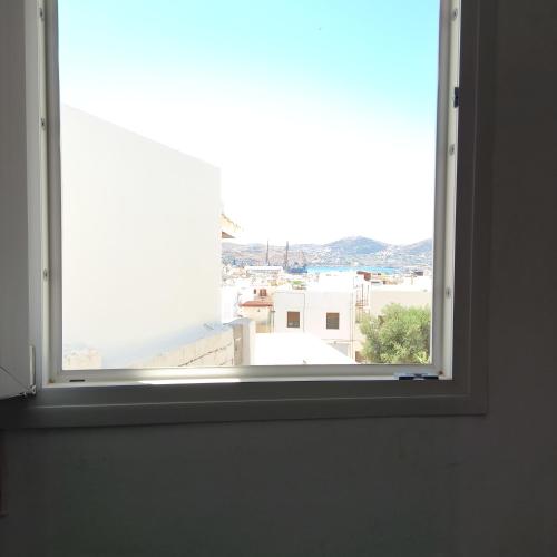an open window with a view of a city at Comfort house in Ermoupoli