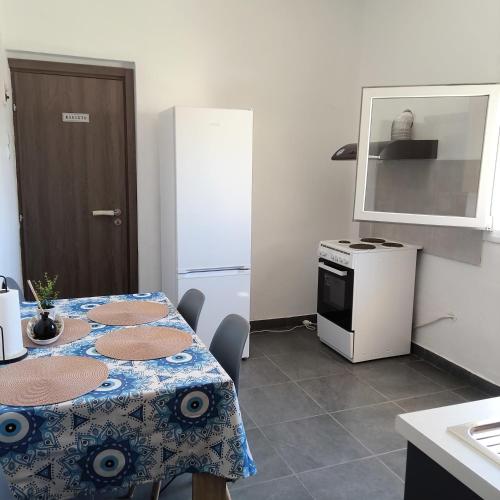 a kitchen with a table with chairs and a refrigerator at Comfort house in Ermoupoli