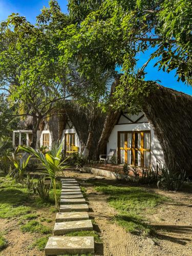 a house with a large tree in front of it at Casa Arrecife San Bernardo del Viento in San Bernardo del Viento
