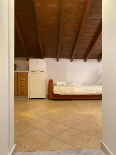 a kitchen with a bed and a refrigerator in a room at Cosy Nest Apartment in the Heart of Samos in Samos