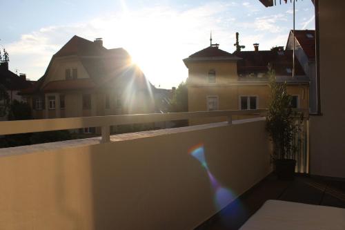 a view from the balcony of a house with the sun shining at Loki's Apartment in Bregenz