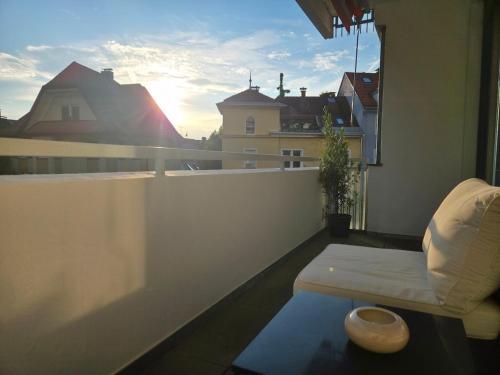 a balcony with a couch and a view of a city at Loki's Apartment in Bregenz