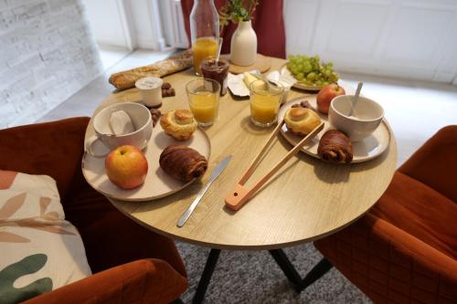 a table topped with plates of food and drinks at Nid normand en bâtisse 1620 - Calme & hyper centre in Pont-Audemer