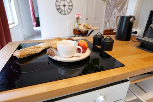 a plate of food and a cup of coffee on a counter at Nid normand en bâtisse 1620 - Calme & hyper centre in Pont-Audemer