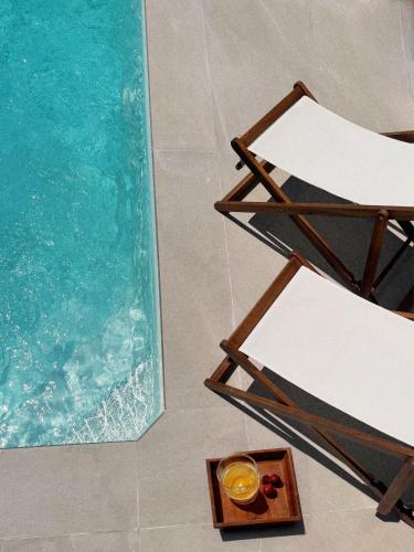 a pool with a chair and a tray of fruit and a plate of food at Villa Mediterranea Tossa in Tossa de Mar