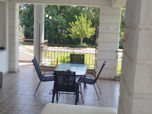 a table and chairs on a porch with a view at Welcoming apartment in Tríkala
