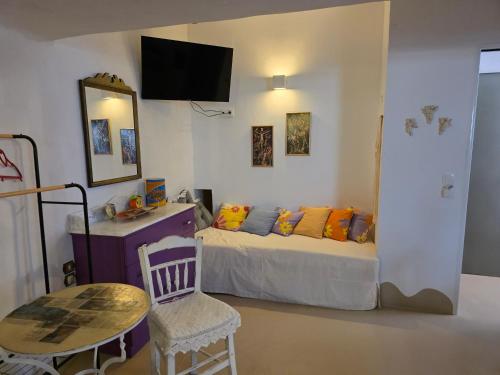 una camera da letto con un letto, un tavolo e uno specchio di Anthippi a Paroikia