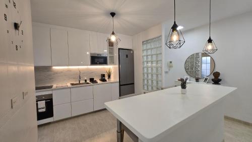 a kitchen with white cabinets and a white counter top at Casa Puerta Roquetas in Roquetas de Mar