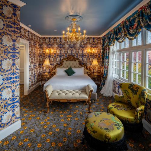 a bedroom with a bed and a chandelier at Prince's Gate Hotel in Rotorua