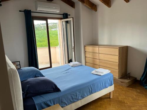 une chambre avec un lit, une commode et une fenêtre dans l'établissement charming villa with pool, à Bastelicaccia