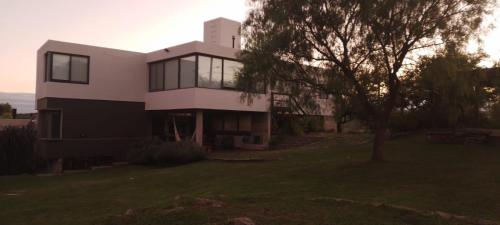 a house with a tree in front of it at CuyenCo in Santa Rosa de Calamuchita
