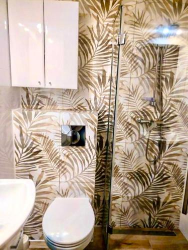a bathroom with a toilet and a wall at Tawerna Murena in Poddąbie