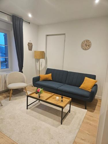 a living room with a blue couch and a coffee table at Le Petit Cocon de Saint-Brieuc in Saint-Brieuc