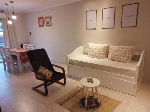 a bedroom with a bed and a chair and a table at San Benito Apart in Tandil
