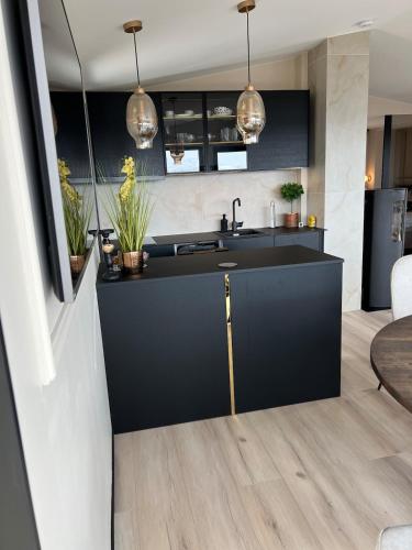 a kitchen with a black counter and a sink at High standard and beautiful view in Tennevika