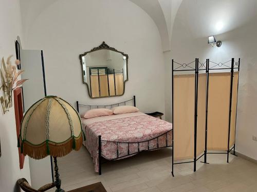 een slaapkamer met een bed en een spiegel bij Maison Remì in Castellana Grotte